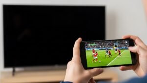 Pessoa a testar uma lista IPTV num telemóvel que funciona, enquanto na TV os canais não carregam, para diagnosticar o problema.